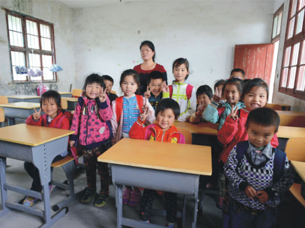 公司為一山村小學(xué)捐贈(zèng)一批課桌椅，孩子們高興地和老師一起合影